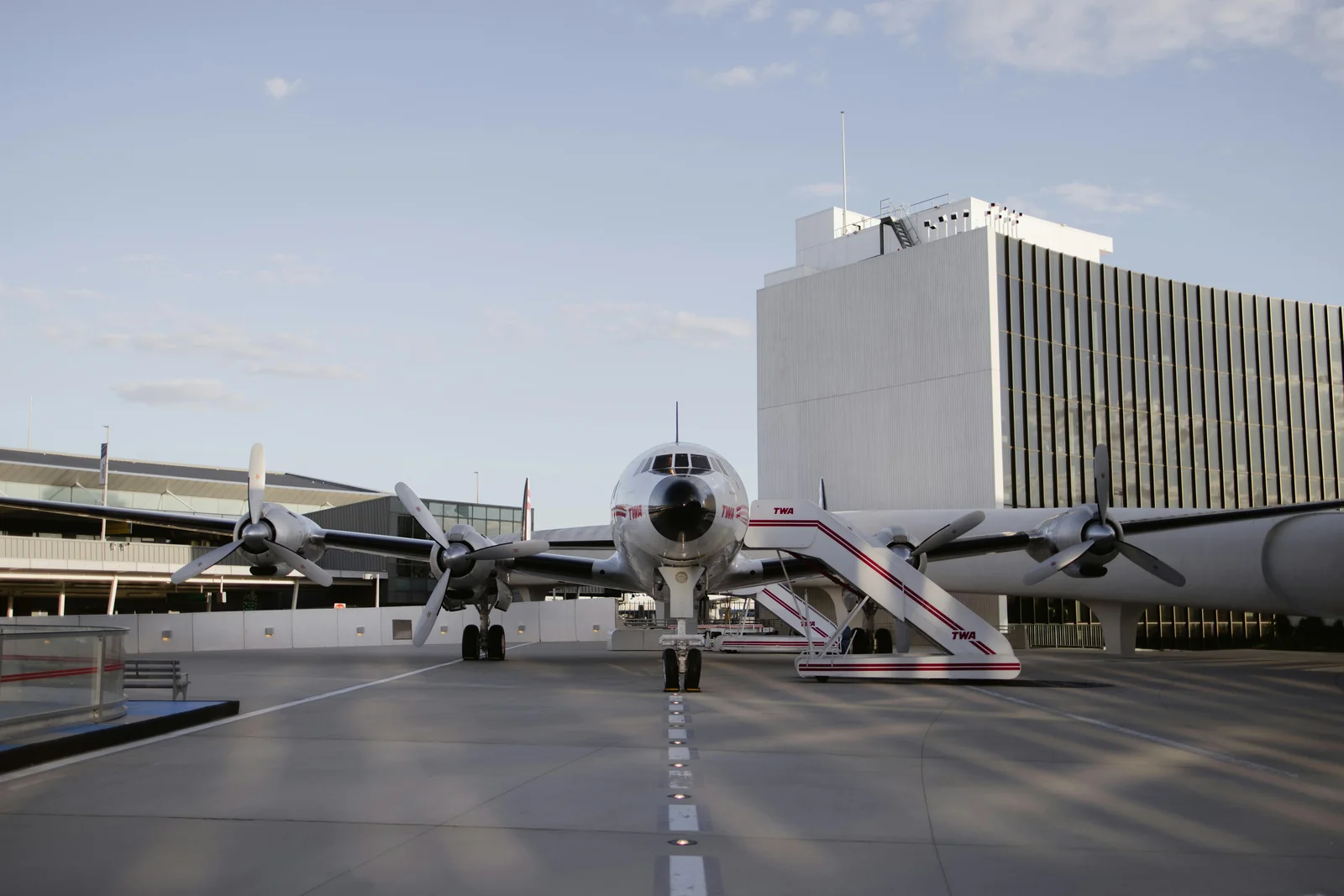 Oświetlony hotel lotniskowy z zaparkowanymi samochodami w nocy