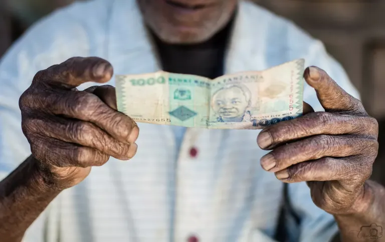 Dłonie z lokalnymi banknotami w ciepłym świetle