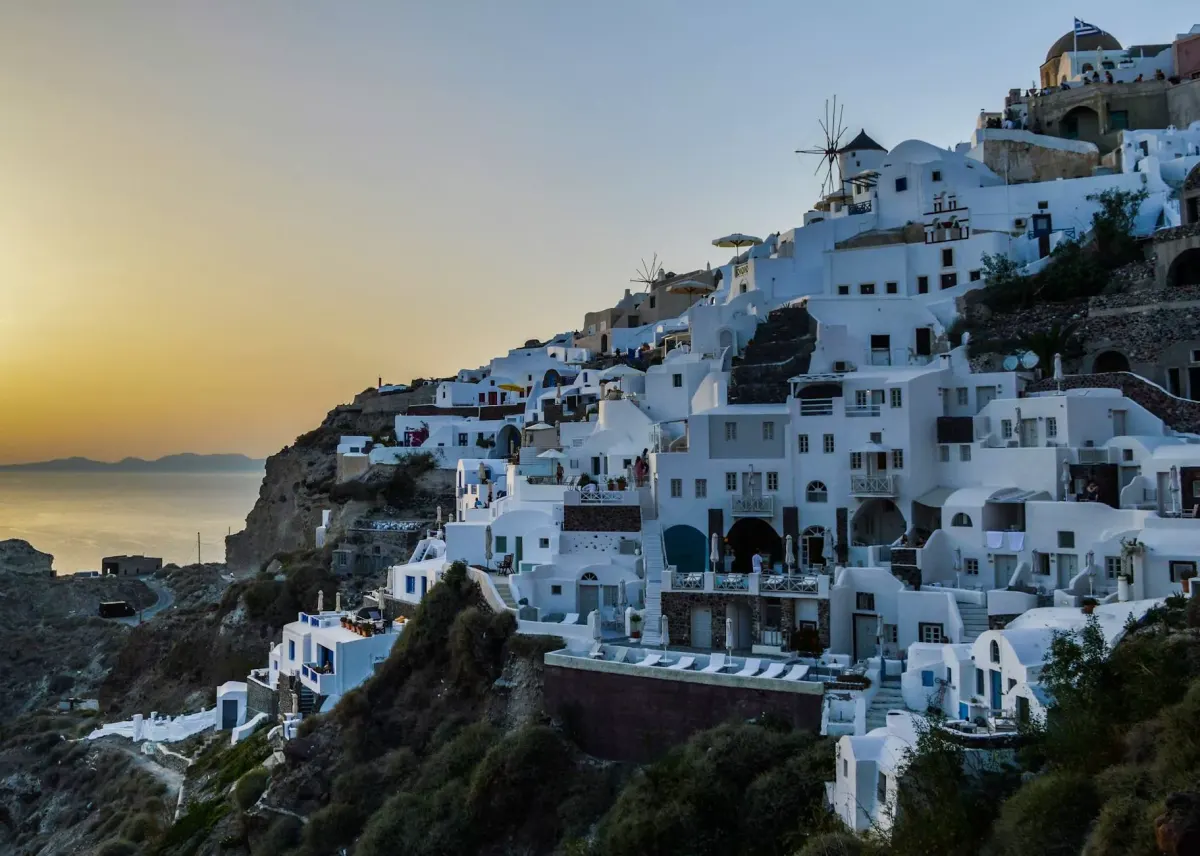 Białe domy Santorini na klifie o zachodzie słońca
