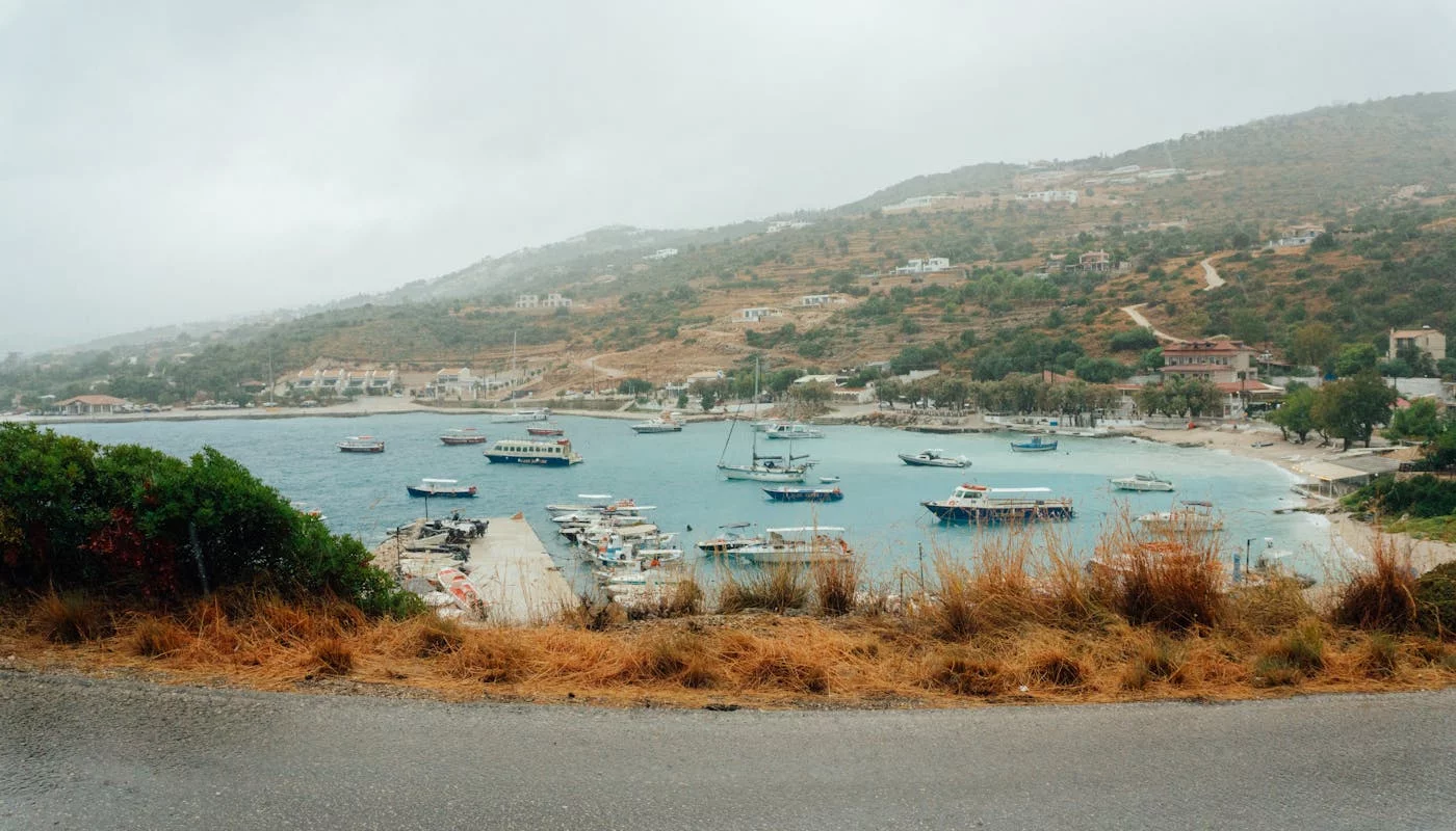 Port w Zakynthos otoczony zielonymi zboczami i łodziami wycieczkowymi w słoneczny dzień