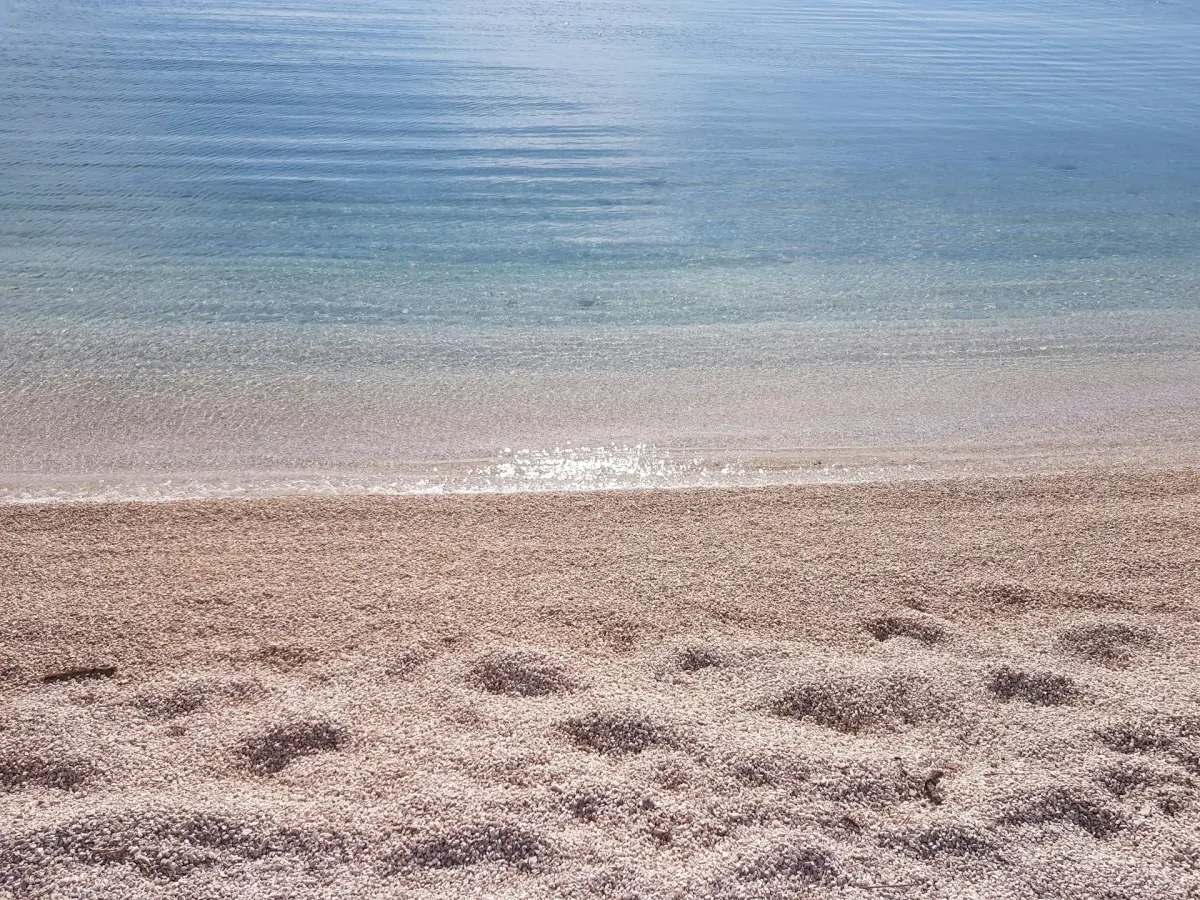 Żwirowa plaża w Chorwacji z łagodnym wejściem do morza