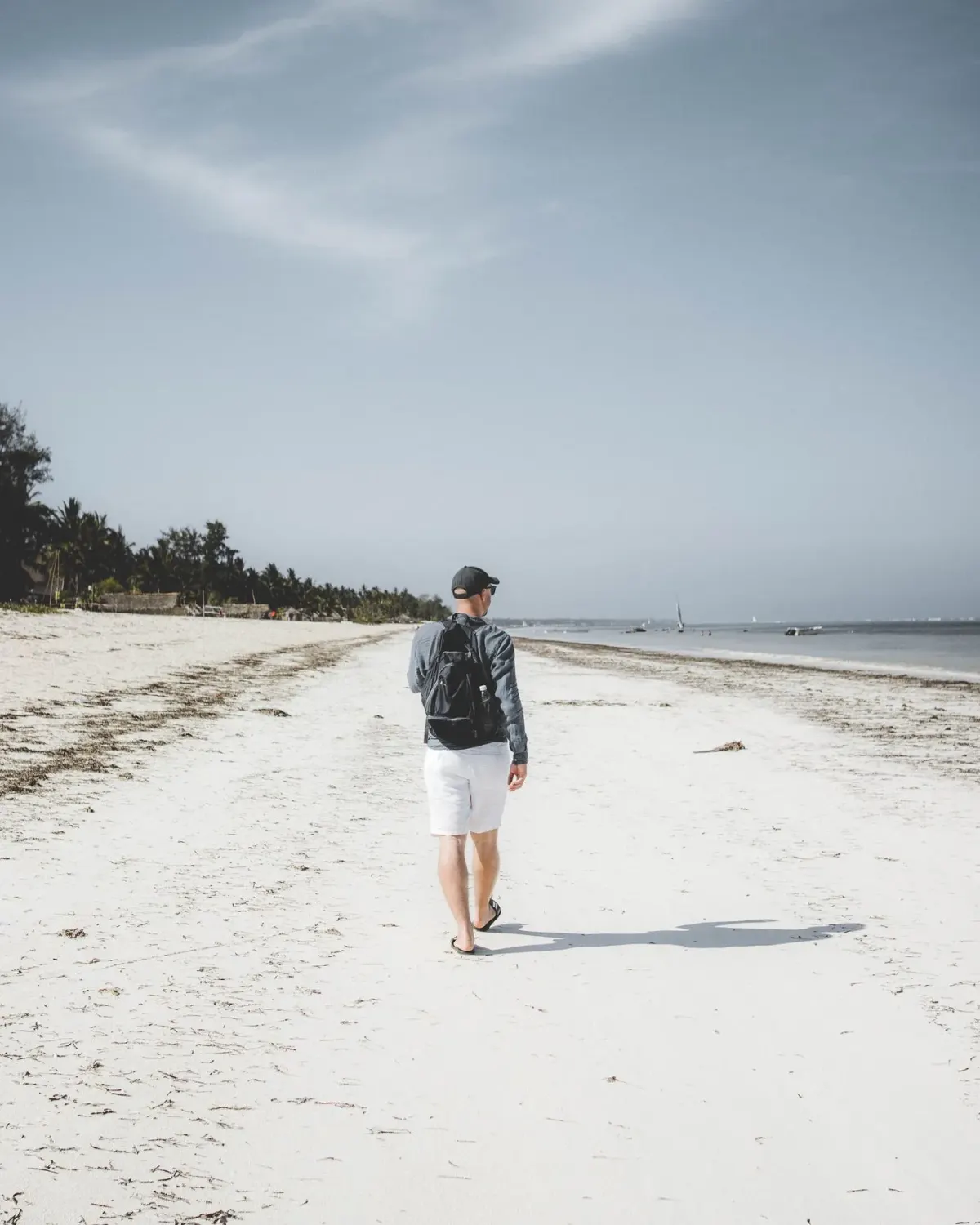 Plaża na Zanzibarze z turystą przy linii oceanu