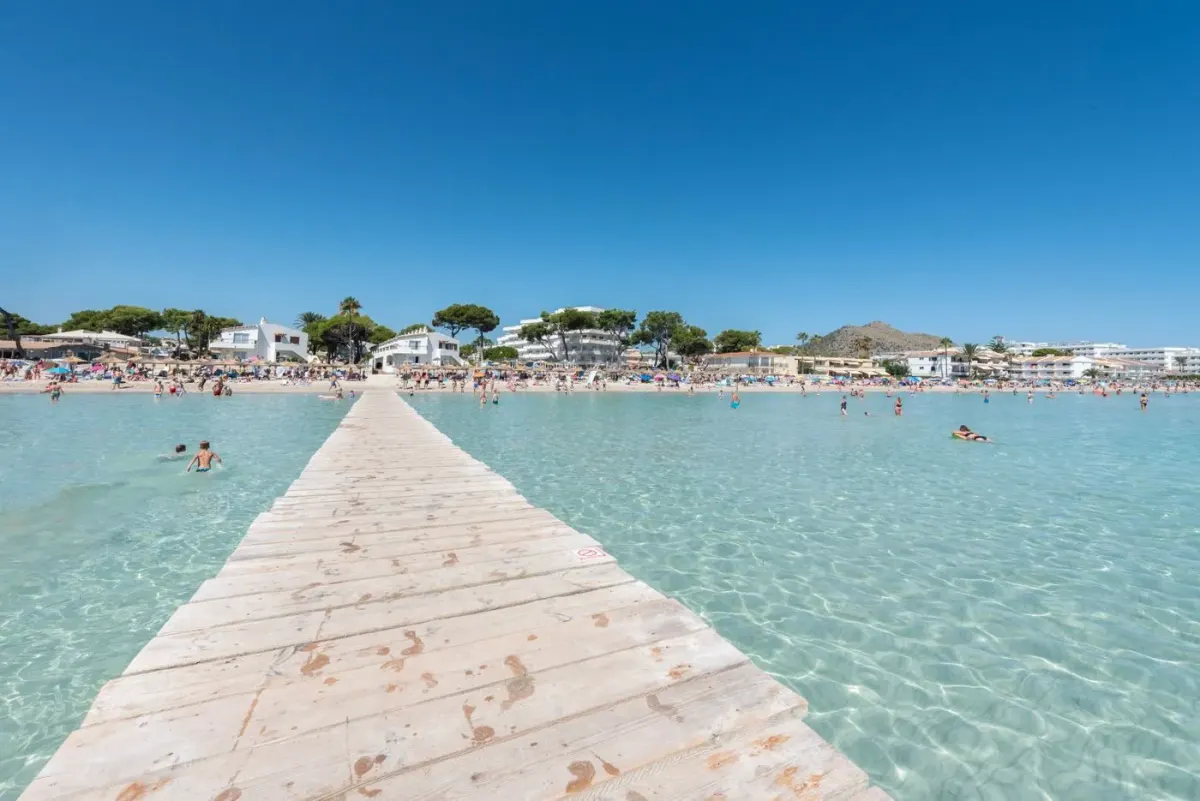 Plaża w Alcúdii na Majorce z turkusową wodą i pomostem