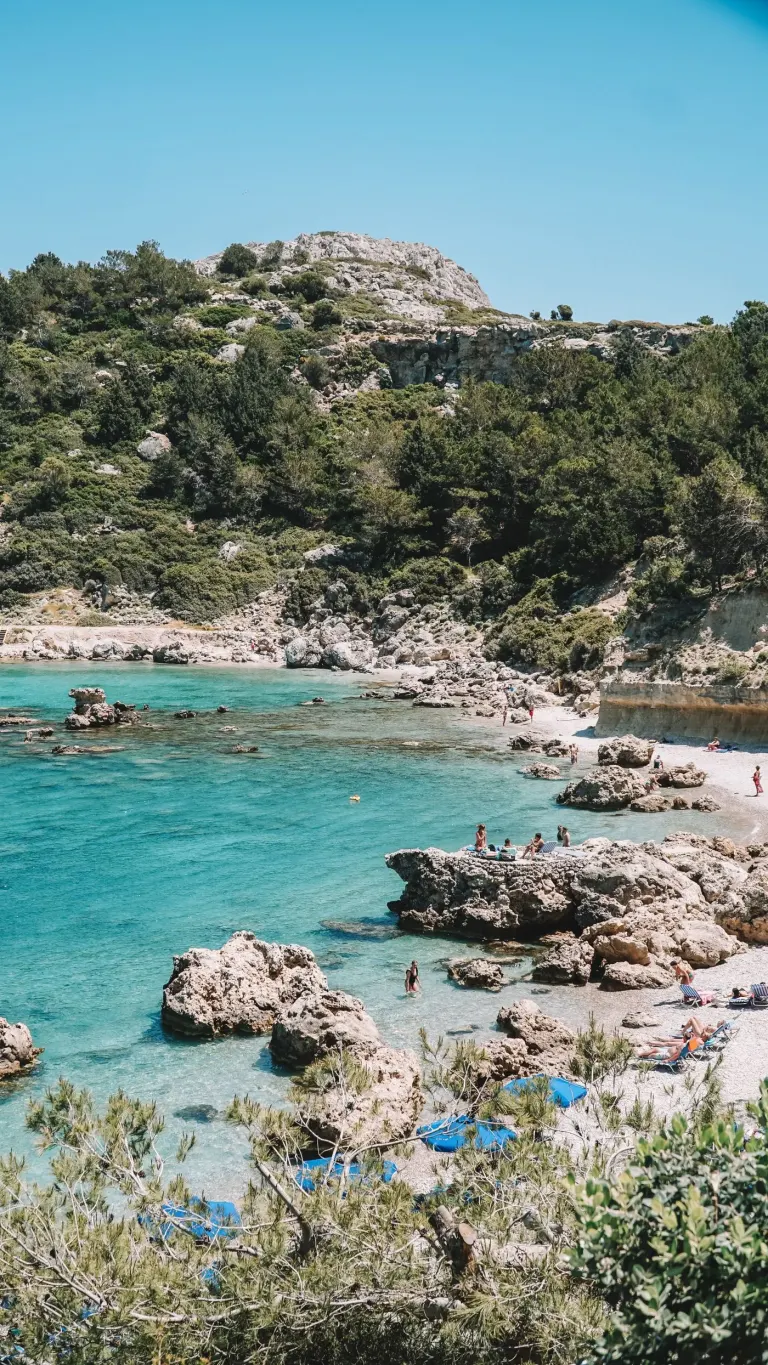 Kamienista plaża i przejrzysta woda na Rodos