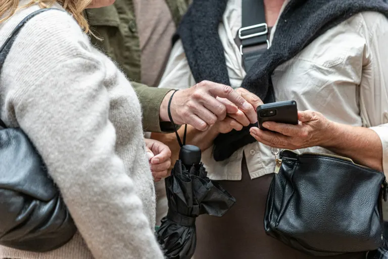 Dwie osoby sprawdzające informacje na smartfonie podczas podróży