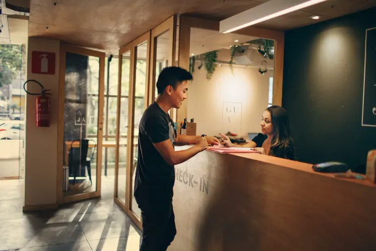 Podróżny przy stanowisku hotelowym z dokumentami