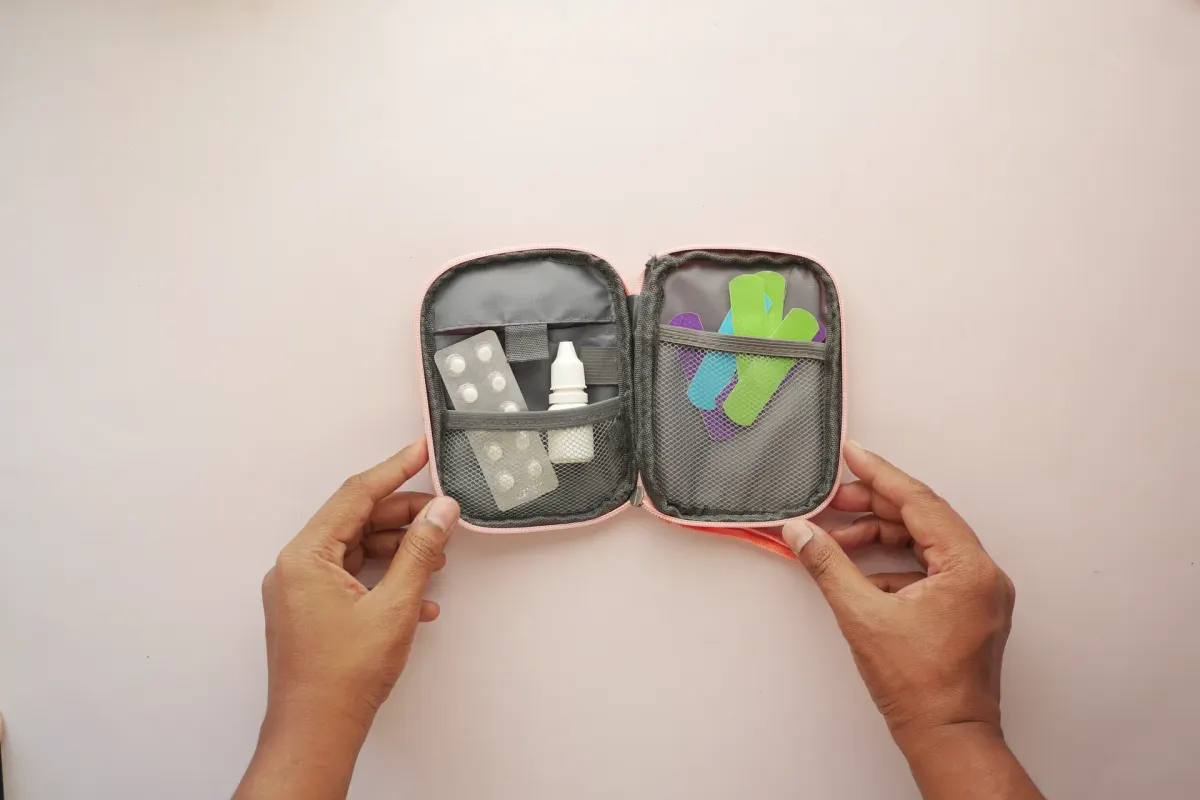 Otwarte etui z tabletkami, opatrunkami i lekami na podróż