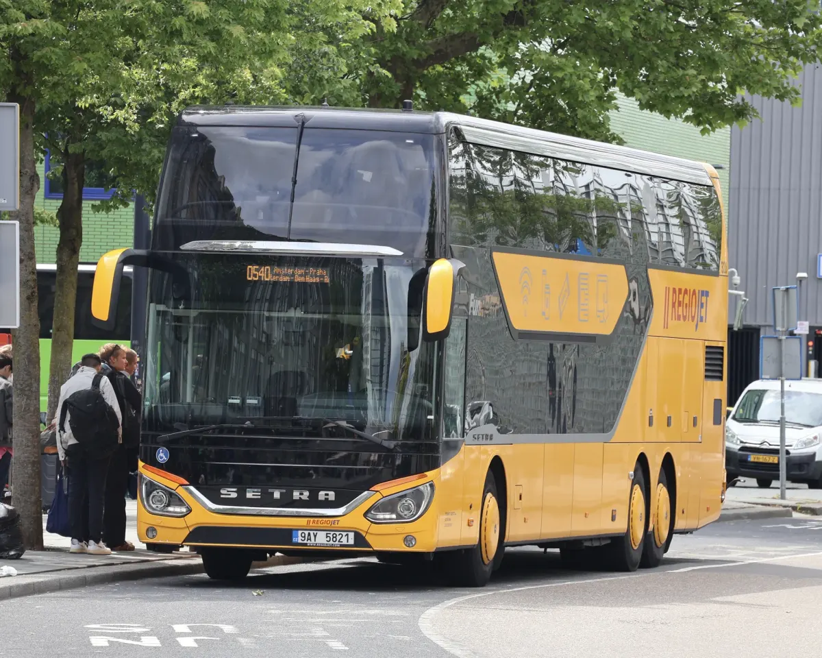 Żółty piętrowy autobus RegioJet na przystanku
