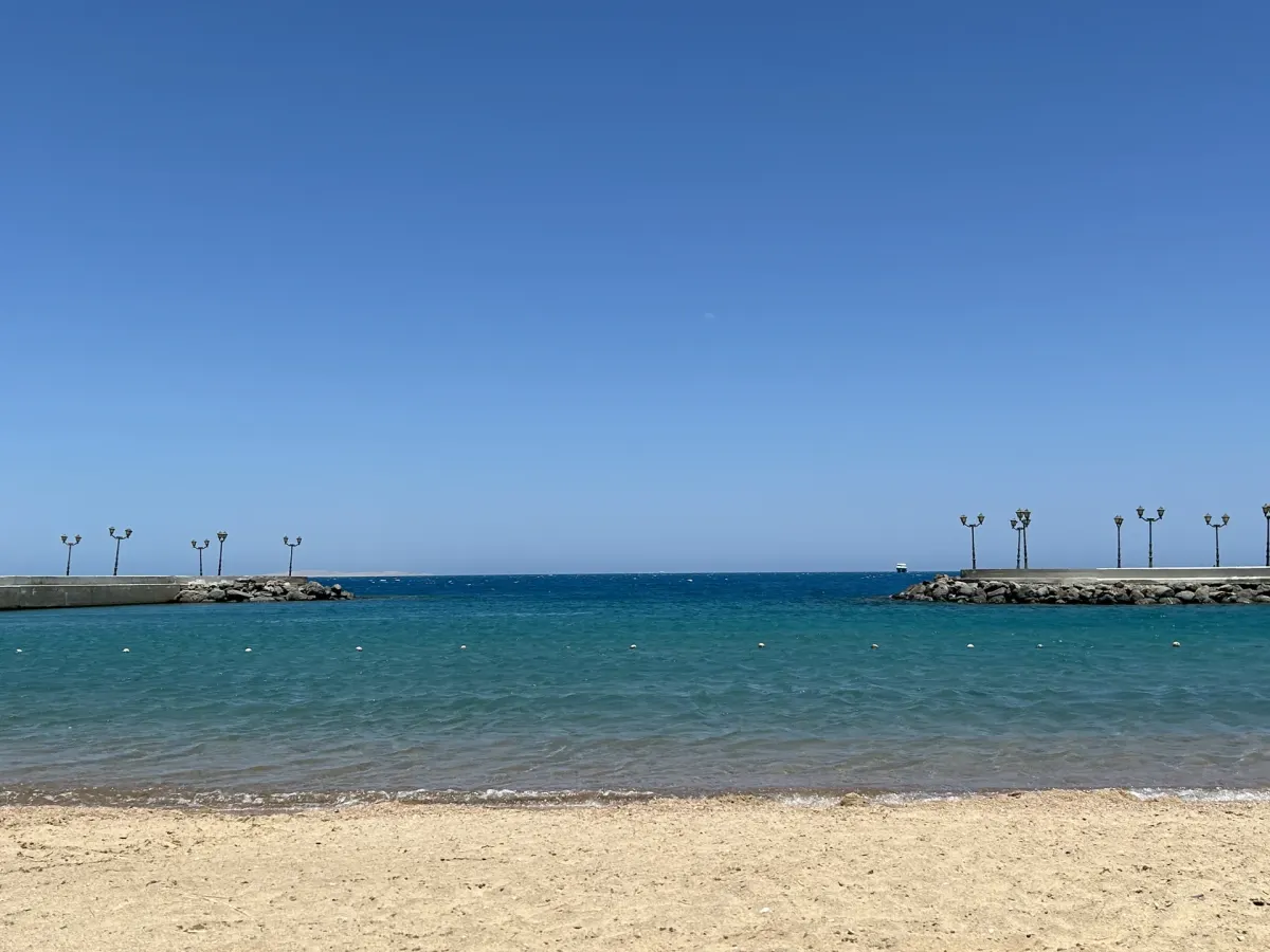 Piaszczysta plaża i wejście do morza między falochronami w Hurghadzie