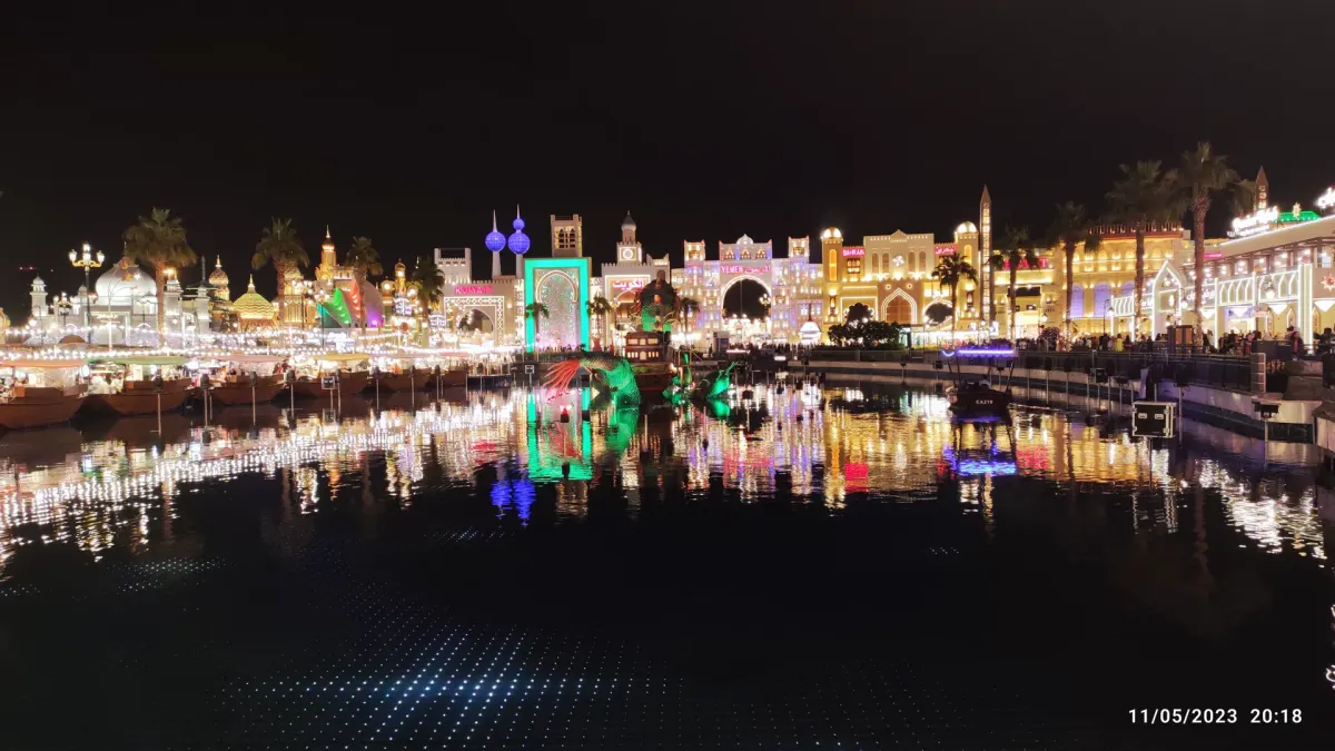 Wieczorny widok na kolorowe budynki i kanał w Global Village w Dubaju